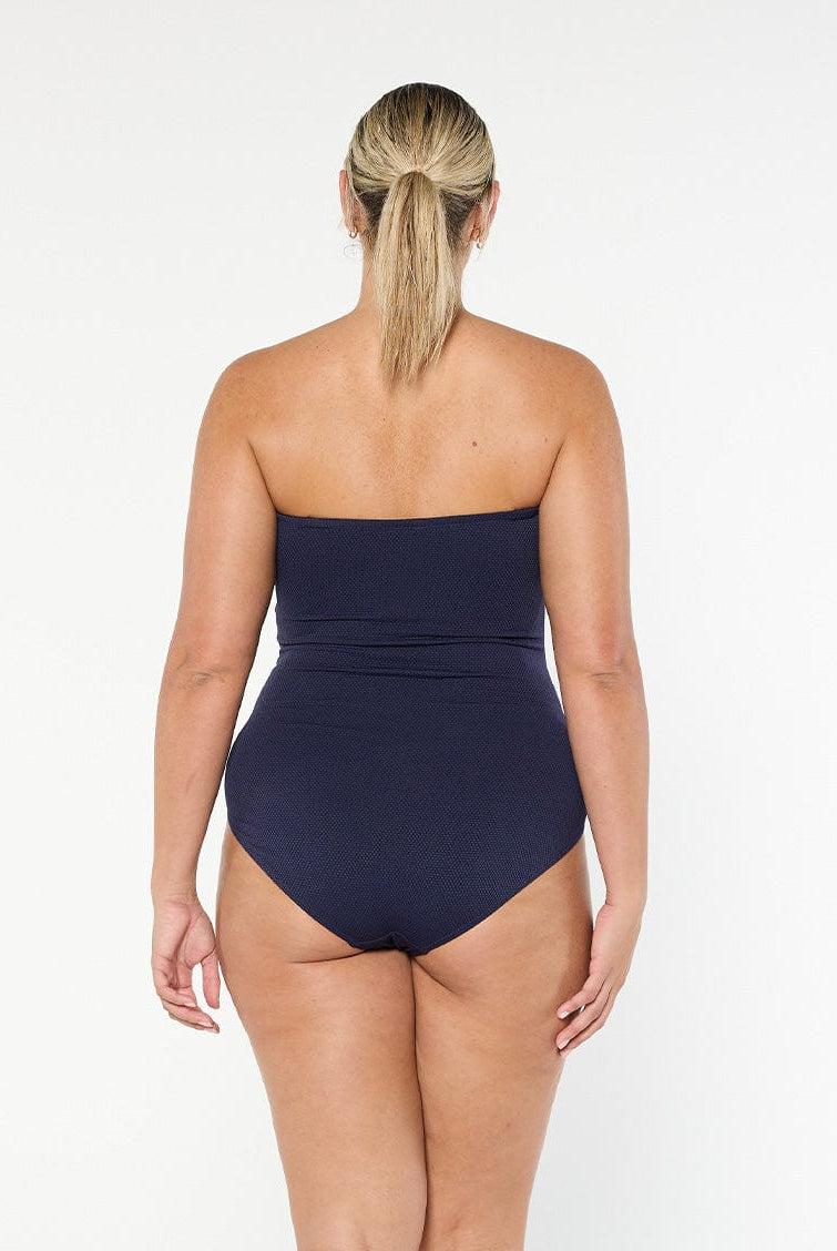 model showing back of textured navy one piece swimsuit