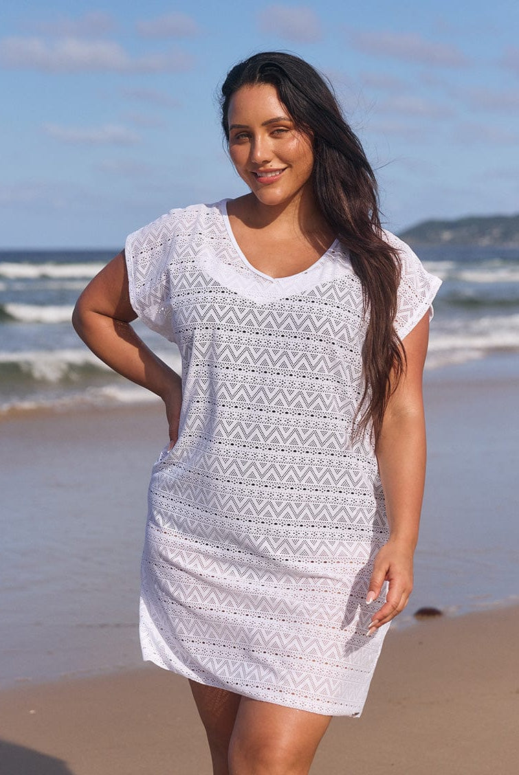 Brunette model on beach wearing white short sleeve mesh dress