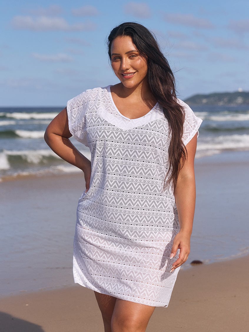 Brunette model on beach wearing white short sleeve mesh dress