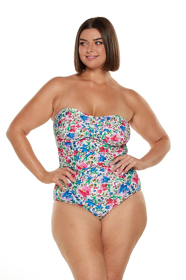 Brunette model wears strapless bandeau one piece in bright floral print