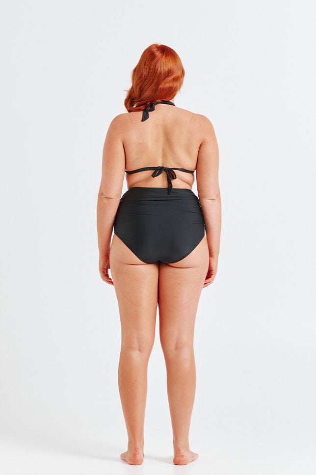 Model wearing extra ruched high waisted bikini bottoms facing back