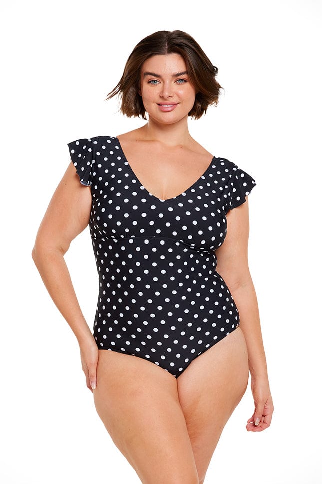 Brunette model wearing v neck black and white dots one piece