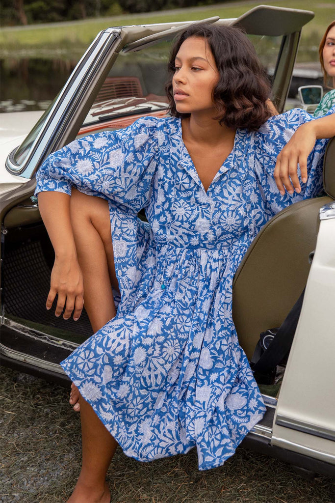 Model sitting on car wearing Blue Boho Mini Dress with Sleeves