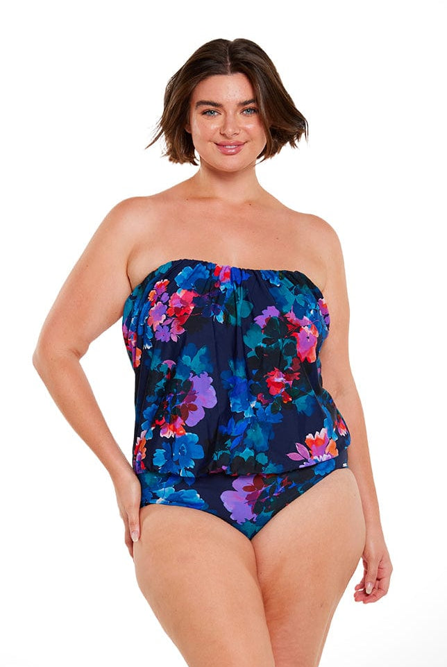 brunette model wears strapless bandeau one piece navy blue floral