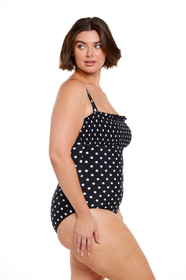 Model posing in black and white dots patterned swimsuit