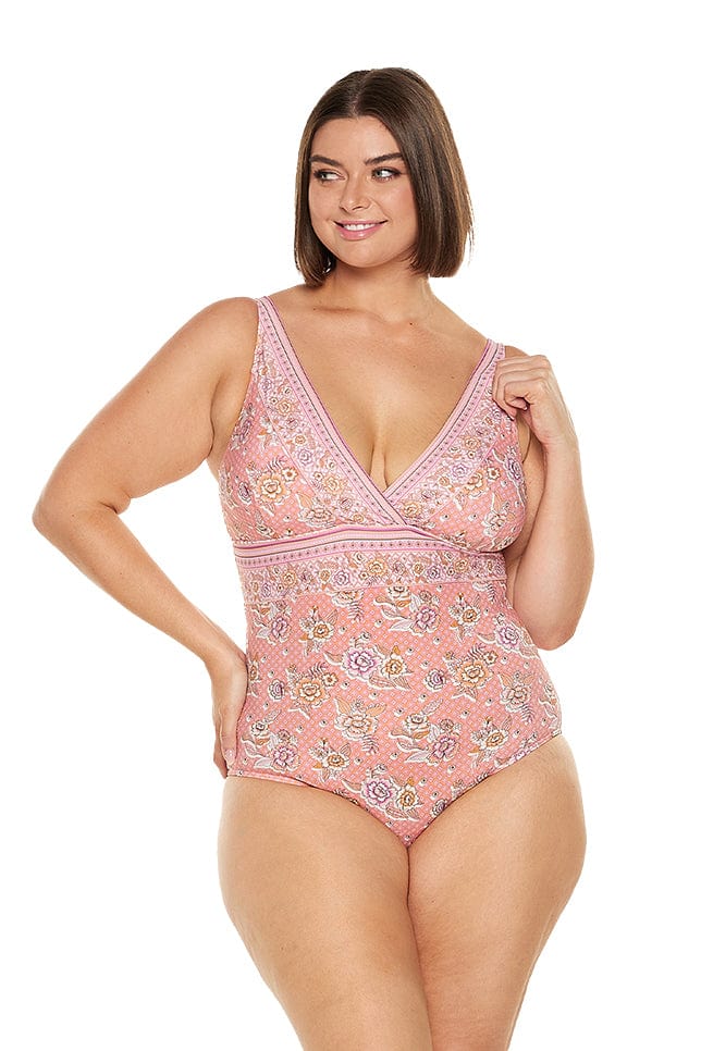 brunette women wears flattering floral pink v neck one piece swimsuit with a shelf bra for bust support