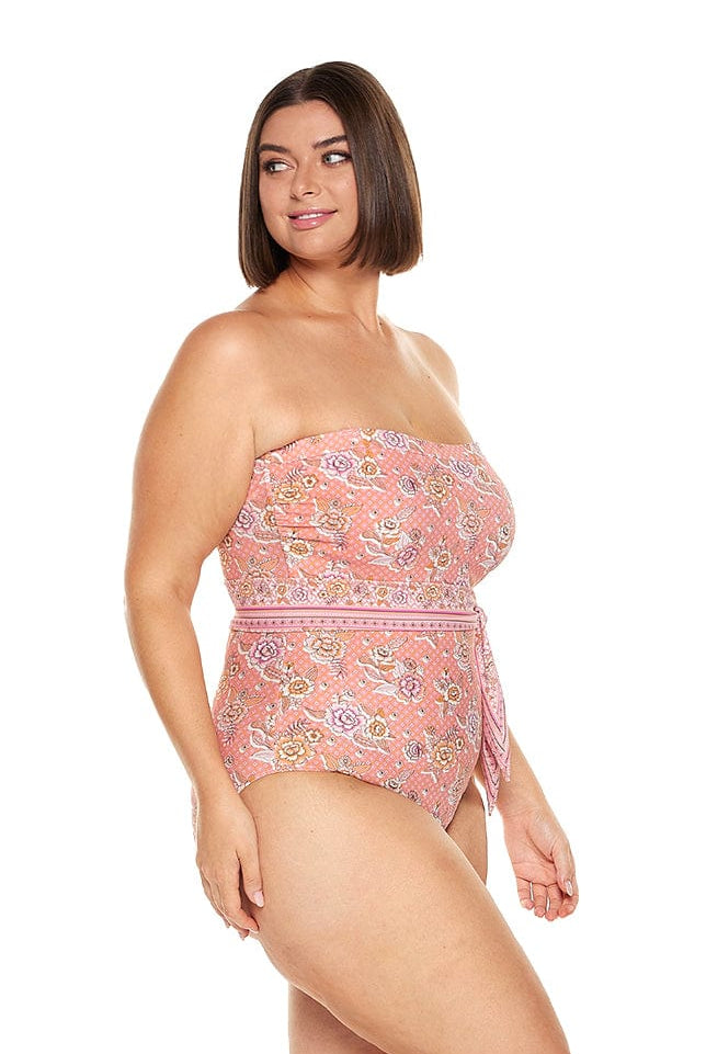 Brunette model wearing pink floral strapless bandeau one piece with underwire support and removable belt