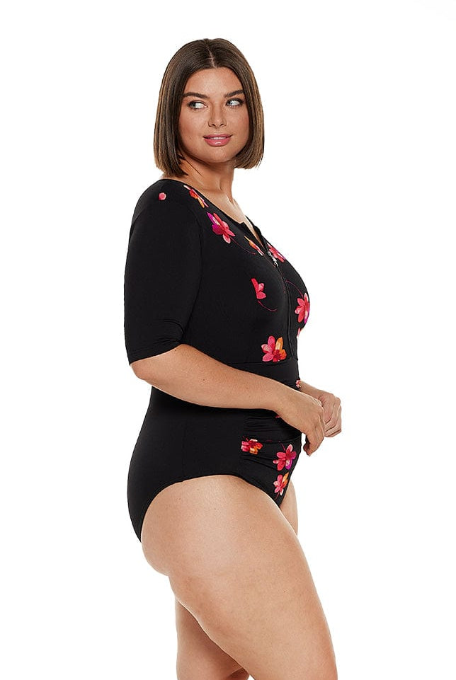 Brunette model wears chlorine resistant zip front one piece with elbow length sleeves