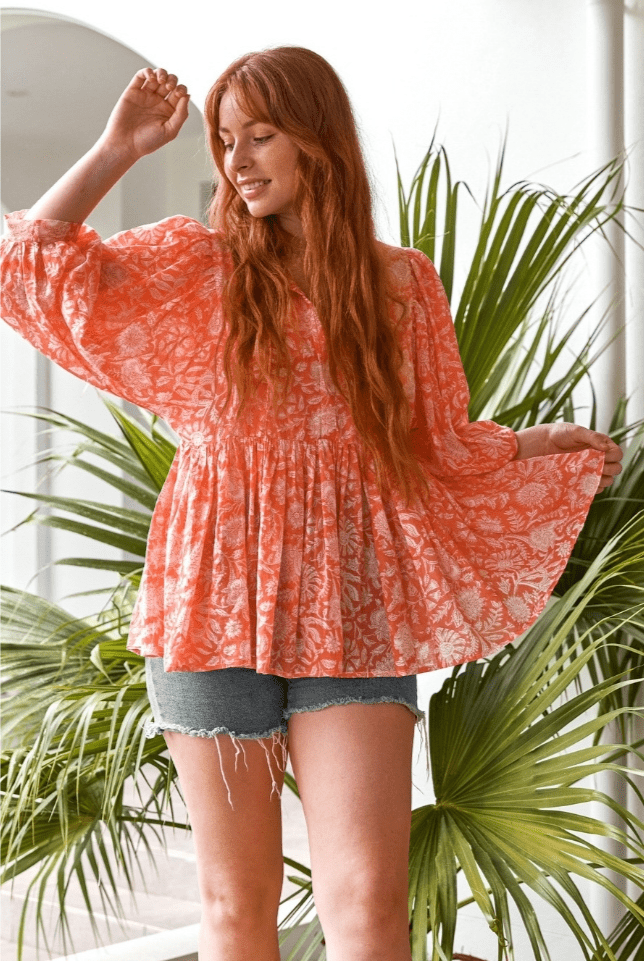 Model posing wearing peach boho peasant blouse