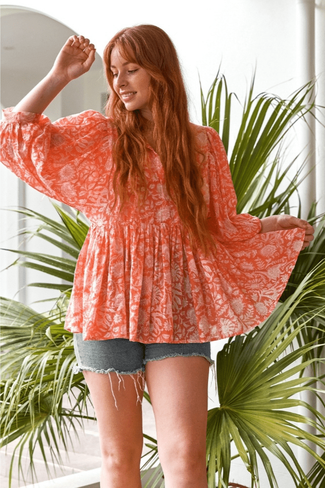 Model posing wearing peach boho peasant blouse
