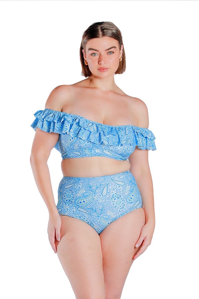 brunette plus size model wearing a blue paisley bikini top that falls off the shoulder with double frills