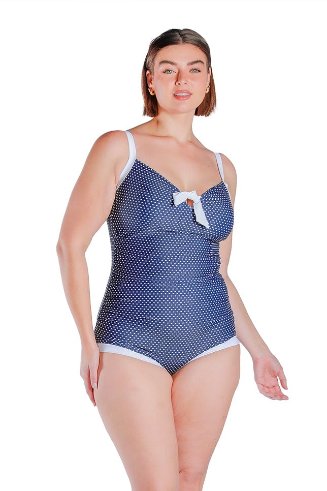 model wears retro style one piece with bow detail at the front and a boyleg