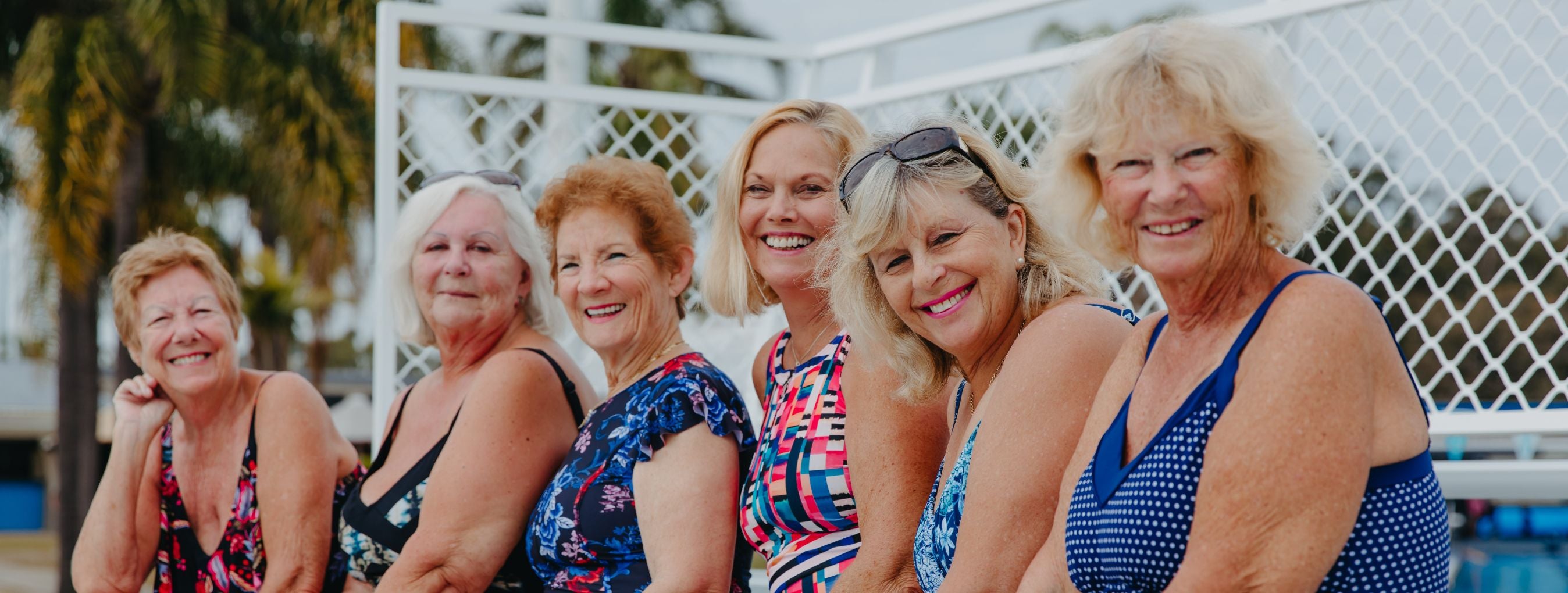 6 women pose together wearing various styles of swimwear