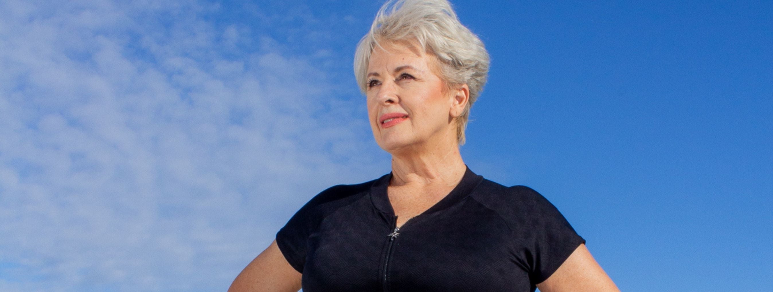 Silver haired model wears Acapulco black and white cap sleeve one piece swimsuit zip up 