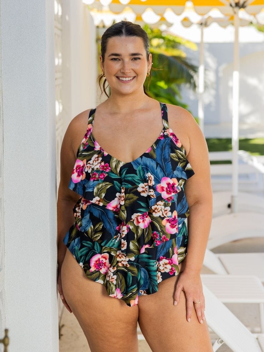 A woman wearing a floral tiered tankini swimsuit outdoors.