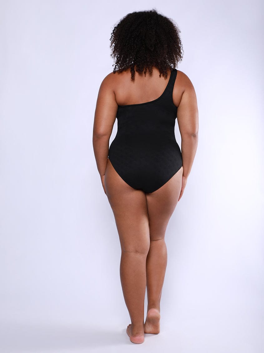 Person wearing a black bodysuit on a white background