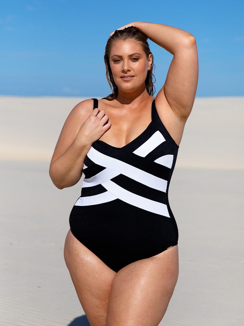 Model on beach wearing flattering criss cross texture one piece 
