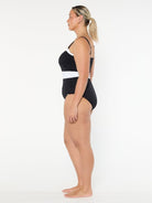 Woman wearing a black and white swimsuit on a white background