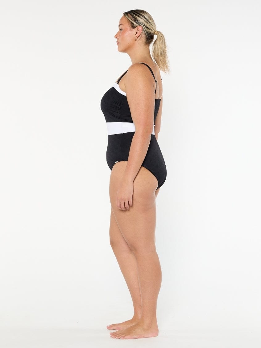 Woman wearing a black and white swimsuit on a white background