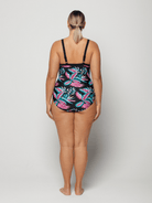 Woman wearing a colorful floral swimsuit on a white background