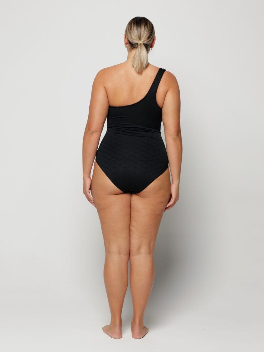 Person wearing a black swimsuit on a plain background