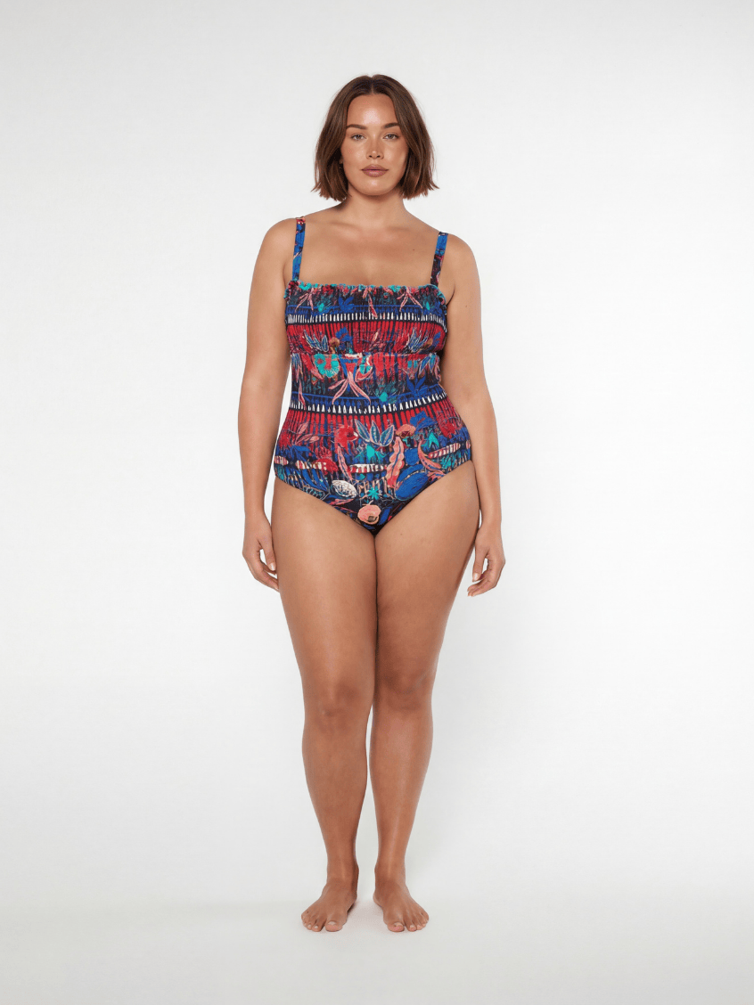 Woman wearing a colorful patterned swimsuit on a white background