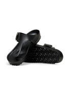 A pair of black slide sandals with adjustable straps and textured soles, shown from a side angle on a white background.