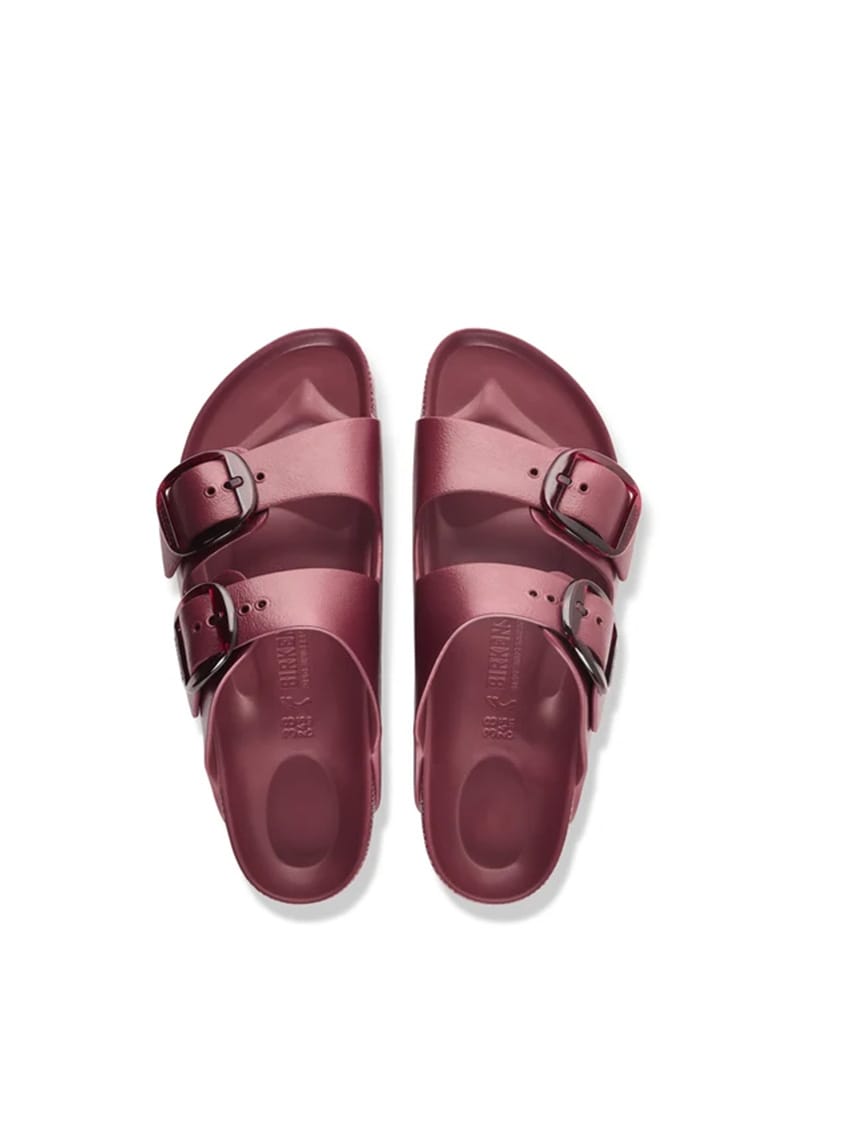 A pair of burgundy double-strap slide sandals with silver buckle details, shown from a top-down view on a white background.