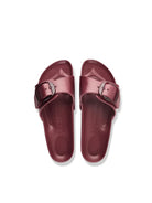 A pair of metallic burgundy slide sandals with double straps and silver-tone buckle details, shown from a top-down view on a white background.
