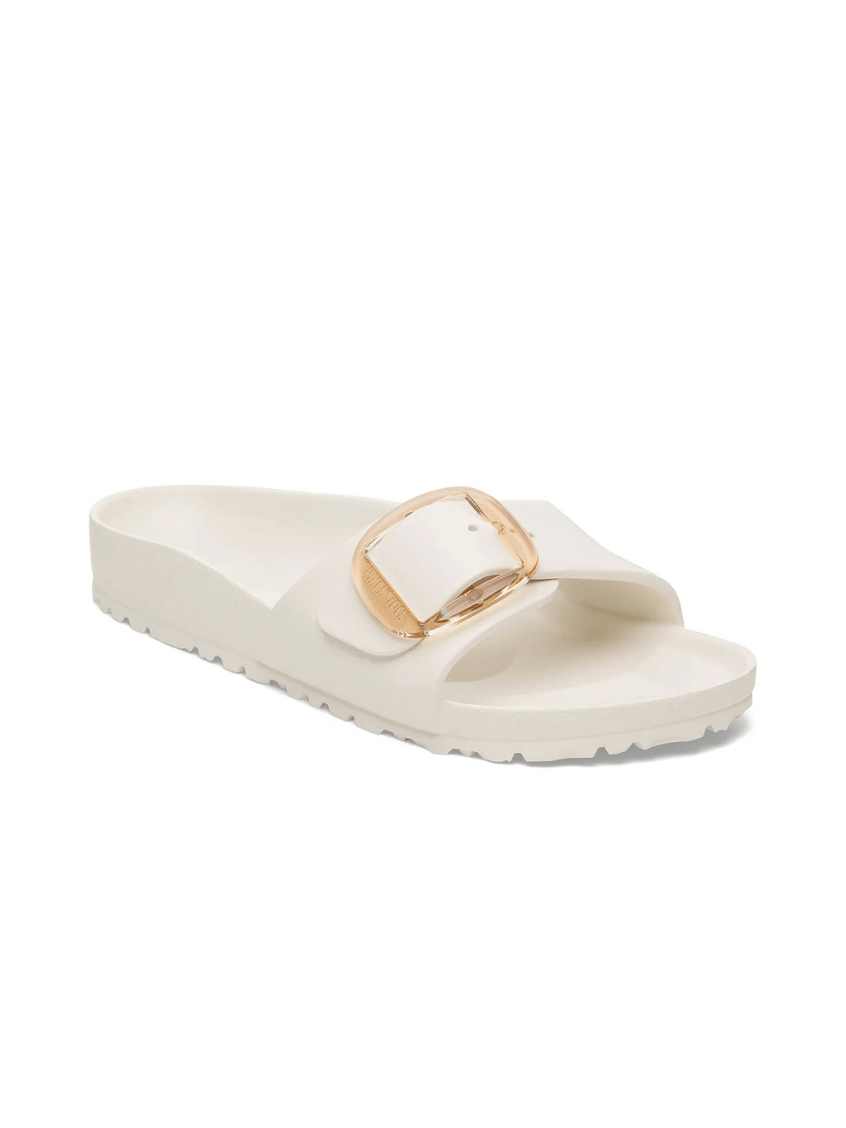 A single cream-colored slide sandal with a wide strap featuring a square gold-tone metal buckle, set against a plain white background.