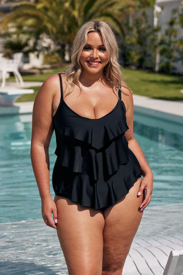 Blonde model wearing black 3 tier one piece next to pool