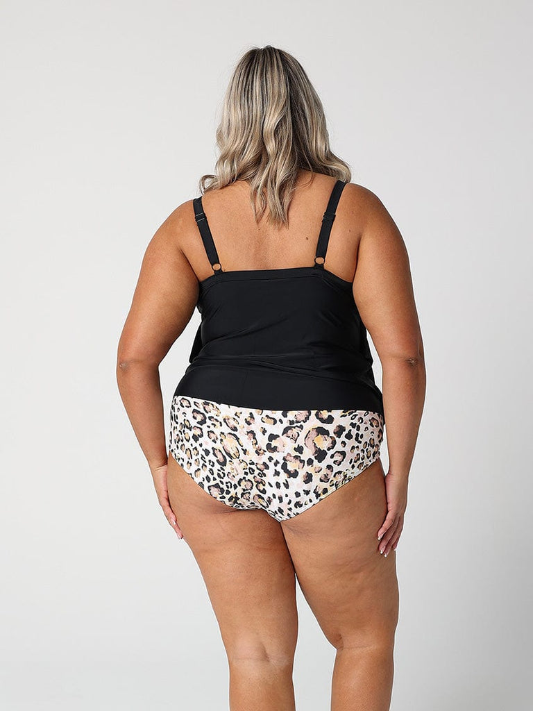 Model wearing a tankini top with ruffle details and adjustable straps