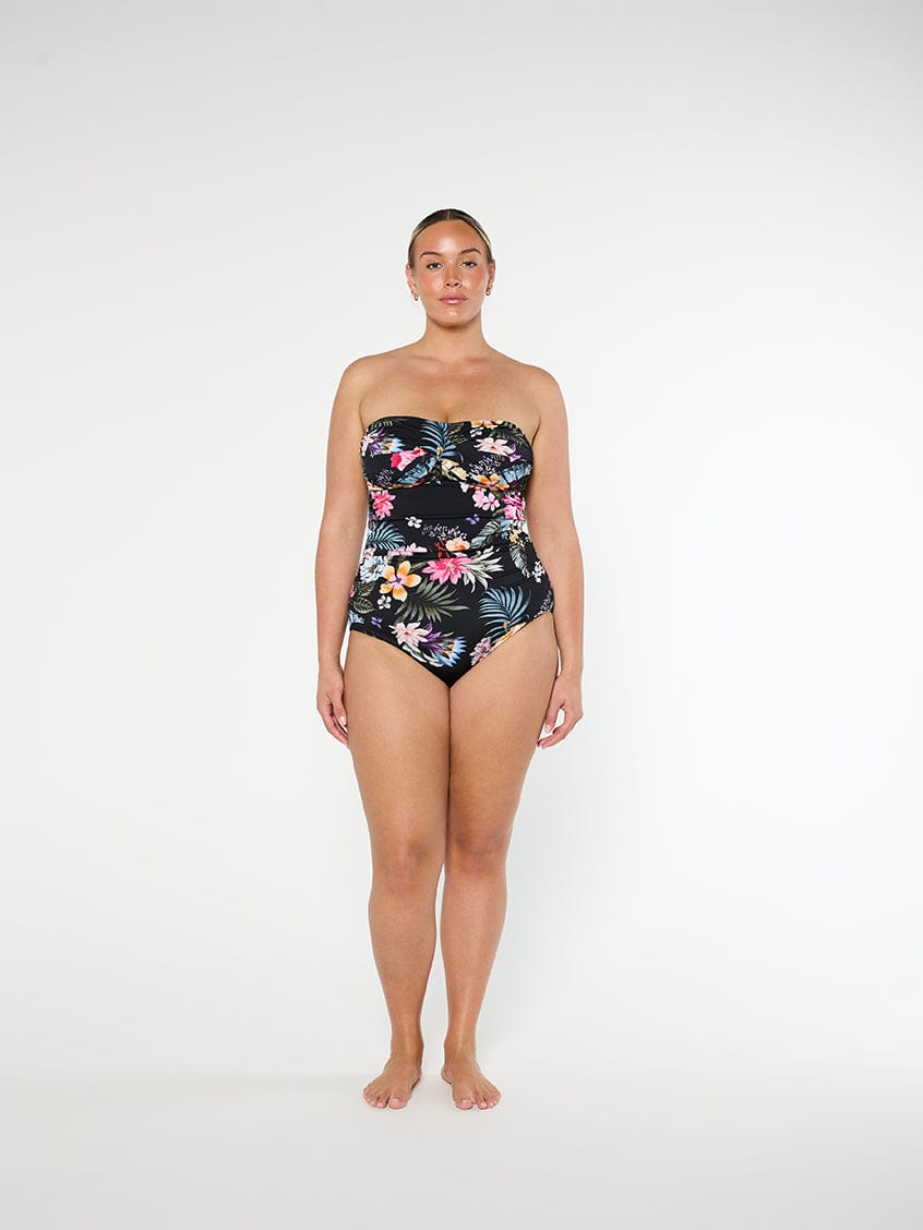 Woman wearing a strapless floral swimsuit on a white background
