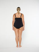 Person wearing a black swimsuit on a white background