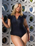 Blonde model wearing black frill sleeve zip up one piece swimsuit