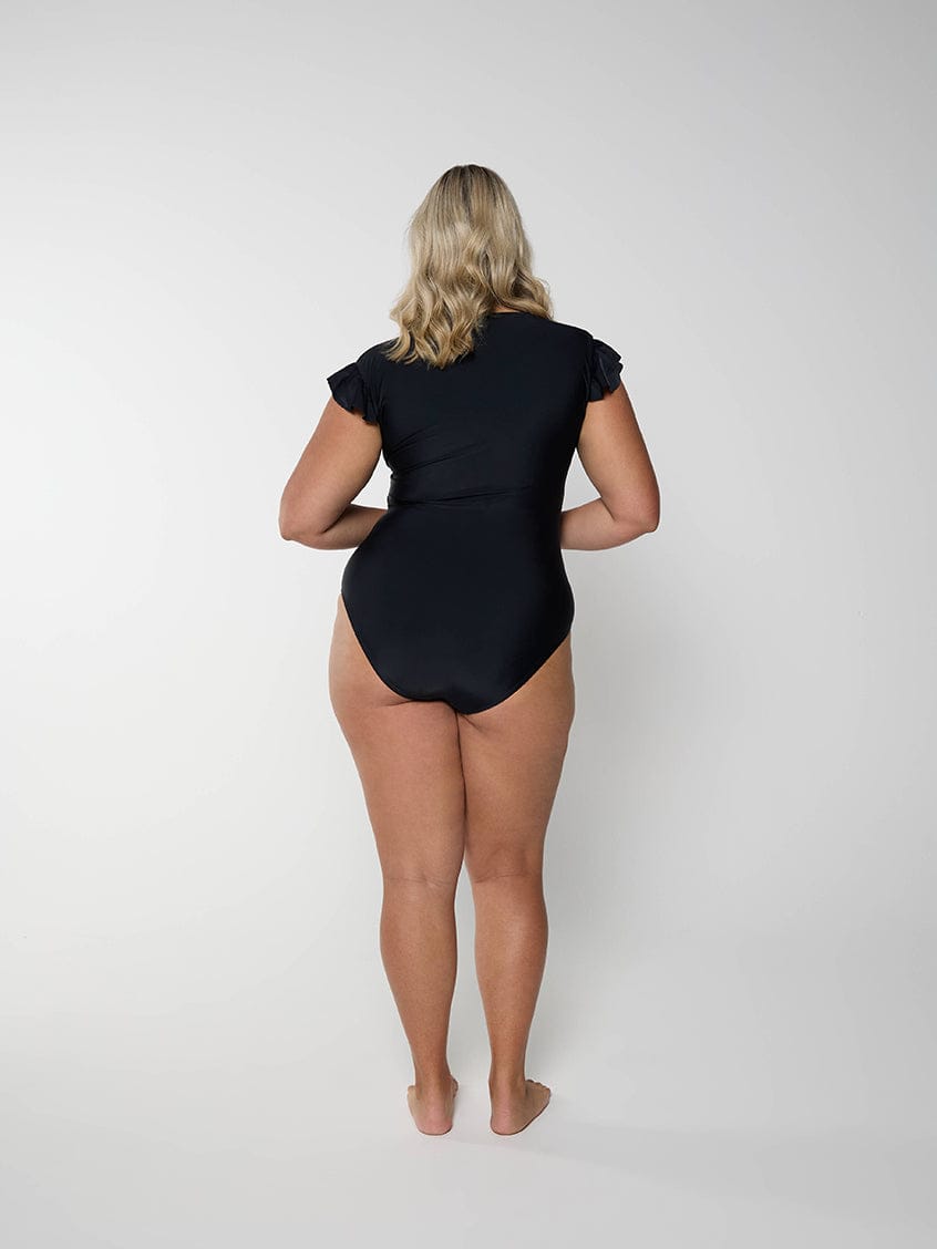 Person wearing a black bodysuit on a white background