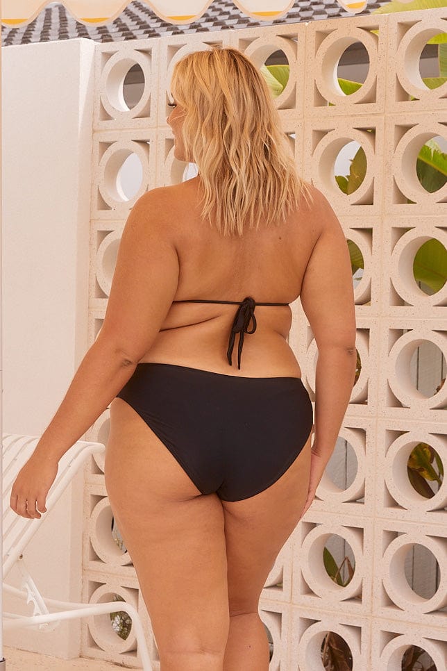 Model showing back of black mid rise mid coverage swim bottoms