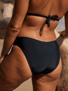 Person wearing a black bikini bottom on a beach