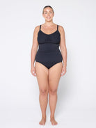 Woman wearing a black swimsuit on a white background