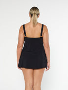 Blonde model wearing modest black swim dress in pool proof fabric