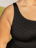 Black tank top worn by a person with a blurred background