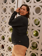 Model wearing a plain black long sleeve rash vest
