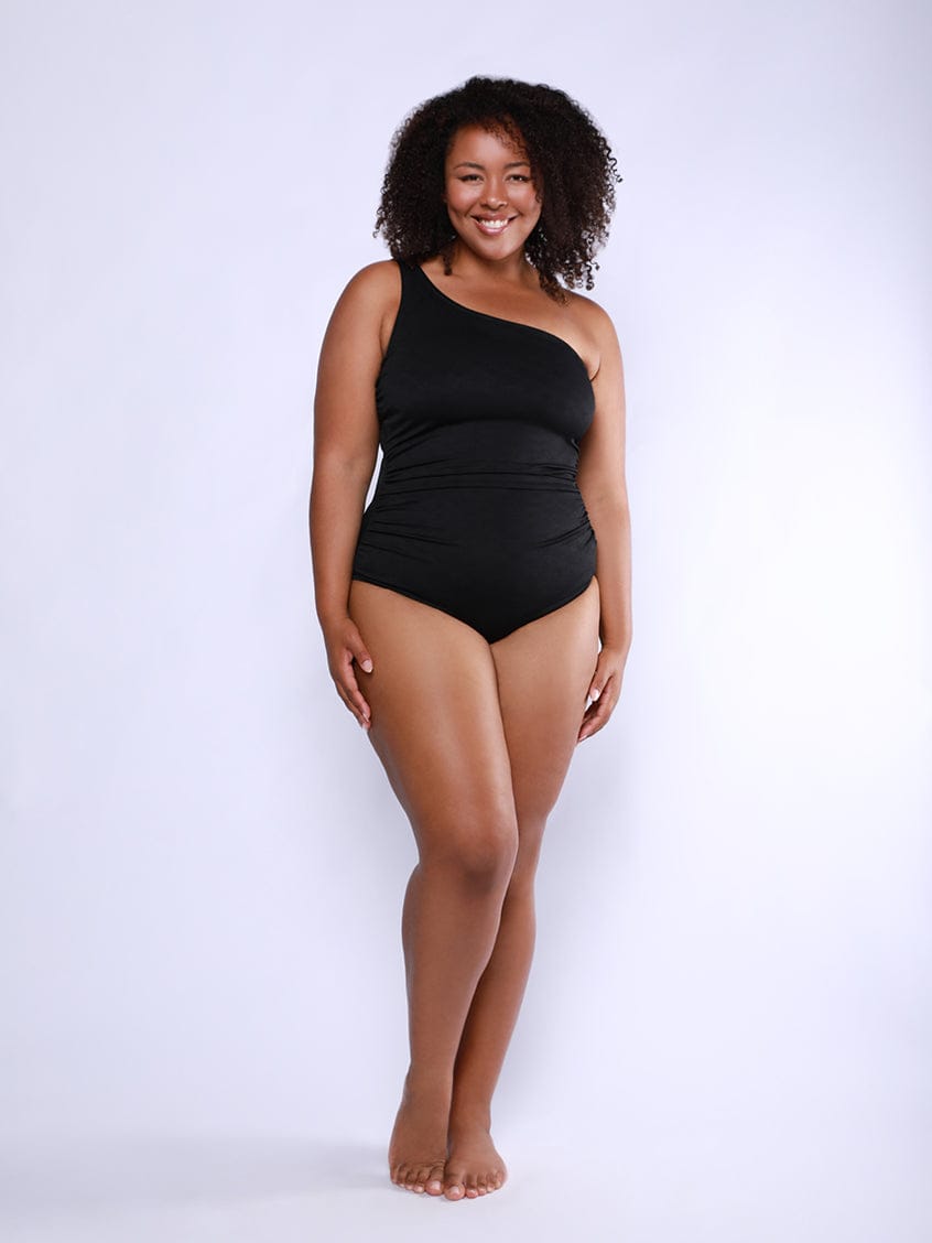 Woman wearing a black swimsuit against a white background