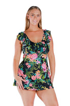 Model wearing frilled swim dress in black floral print