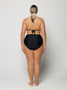 Person wearing a black bikini on a white background