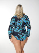 Blonde model shows back of figure-flattering blue floral rash vest with long sleeves