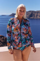 Model wearing blue tropical print long sleeve rash vest