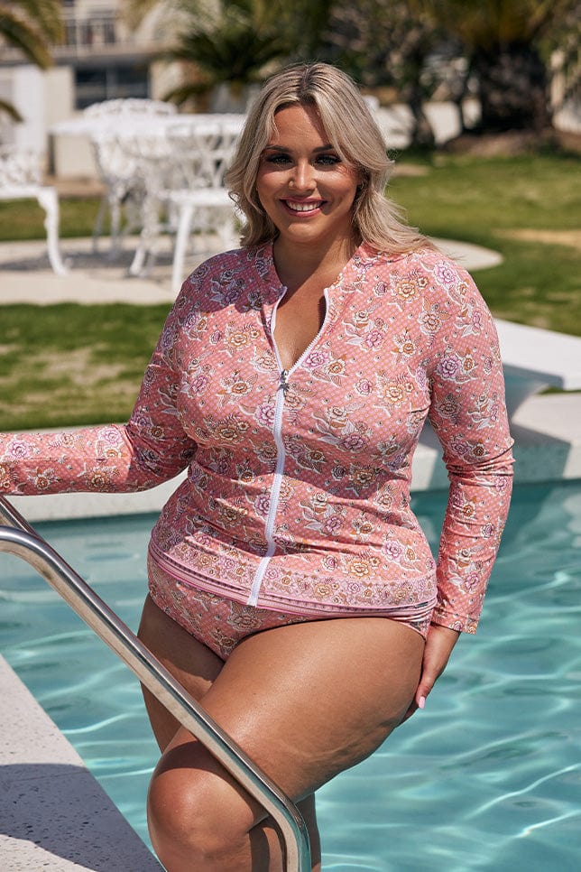 Model wearing womens pink and apricot floral rash vest with full front zip and long sleeves