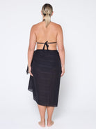 Woman wearing a black sarong on a white background