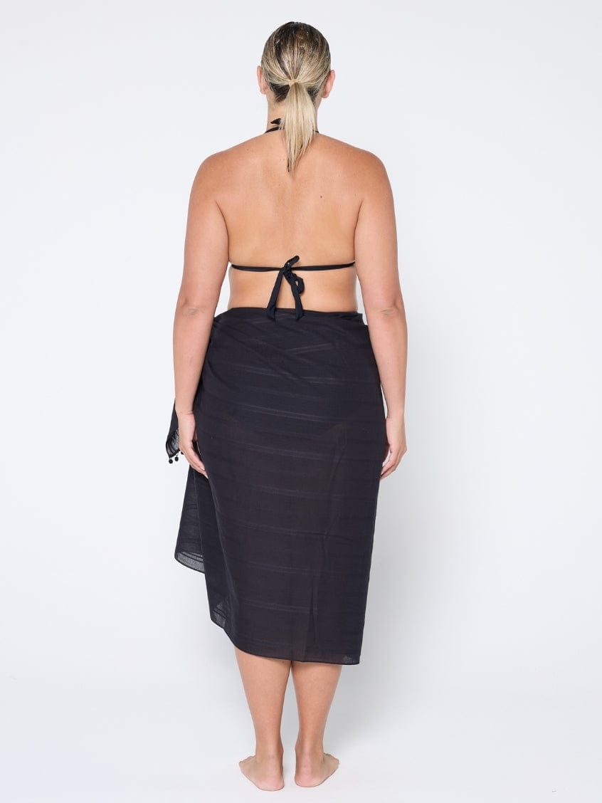 Woman wearing a black sarong on a white background